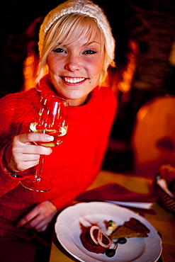 Young woman enjoying a glass of wine at dinner