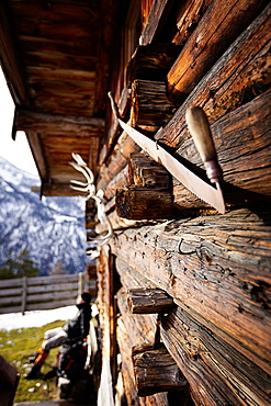 Wooden hut and hiker taking a rest, descent from Unnutz Mountain (2078 m), Rofan Mountains, Tyrol, Austria