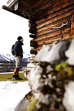 Hiker and wooden alpine hut, descent from Unnutz Mountain (2078 m), Rofan Mountains, Tyrol, Austria