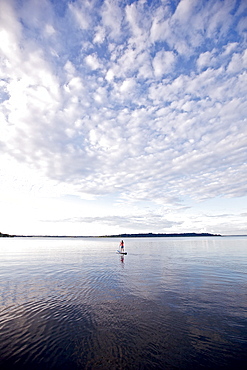 Woman stand up paddling on lake Chiemsee, Chiemgau, Bavaria, Germany