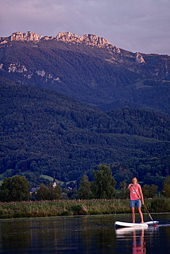 Woman stand up paddling on lake Chiemsee, Chiemgau, Bavaria, Germany