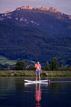 Woman stand up paddling on lake Chiemsee, Chiemgau, Bavaria, Germany