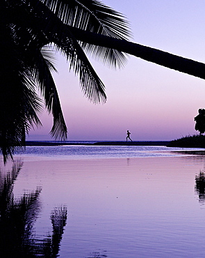 Man running along beach in sunet, Dominica, Lesser Antilles, Caribbean