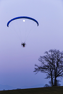 Motor-Paraglider and moon at dusk, Penzberg, Bavaria, Germany