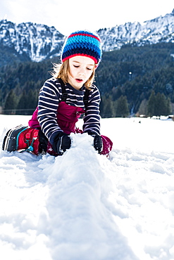 boy forming snowballs in winter, Pfronten, Allgaeu, Bavaria, Germany