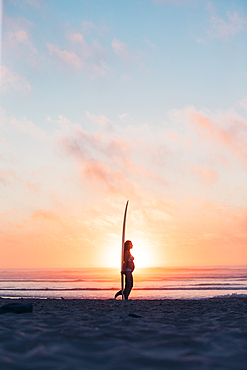 pregnant woman standing with surfboard on the beach, surfing, pregnancy, Portugal