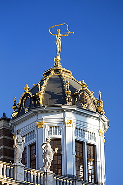 Close-up of building domed turret with gold trim and gold statue on top of dome with blue sky, Brussels, Belgium