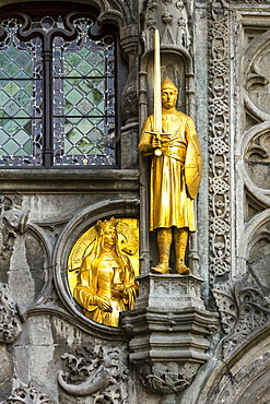 Close-up of a gold statue on a decorative building facade, Bruges, Belgium