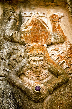 Close-up view of human figure splayed like a toad and holding a purple stone, carved on the side of a Mayan ruin, Tulum, Quintana Roo, Mexico