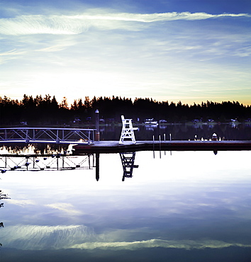 A lifeguard chair on the dock of a tranquil lake at sunrise, Lakeside Bible Camp, Whidbey Island, Washington, United States of America