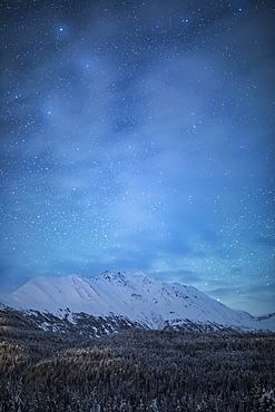 The faint glow of Aurora Borealis in the night sky illuminates the sparse cloud over Moose Pass, Kenai Peninsula, South-central Alaska, Moose Pass, Alaska, United States of America