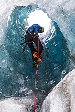 Man exploring an ice cave, South Coast, Iceland