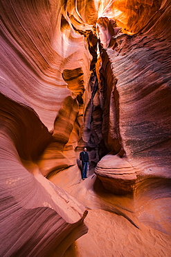 Man standing in a Slot Canyon known as Canyon X, near Page, Arizona, United States of America