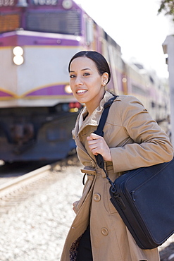 Hispanic woman standing at a railway station