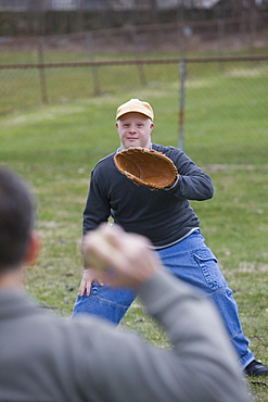 Disabled man playing baseball with his son Disabled man smiling with his son with Down Syndrome