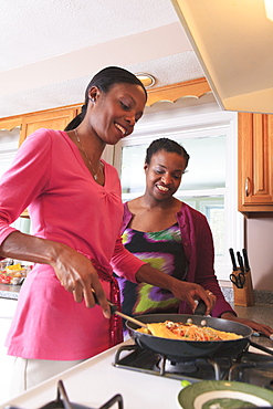 Two sisters cooking in the kitchen, one with learning disability