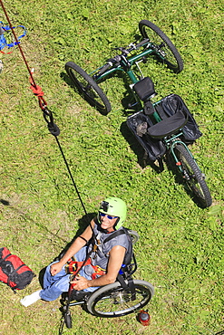 Man with spinal cord injury sitting in a wheelchair preparing for rock climbing