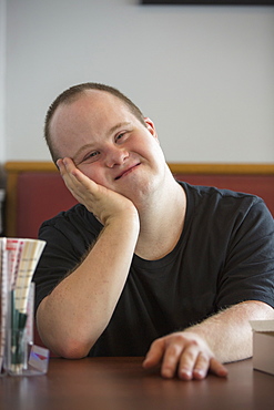 Portrait of happy waiter with Down Syndrome in a restaurant