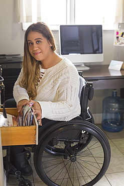 Woman with Spinal Cord Injury arranging things in her room