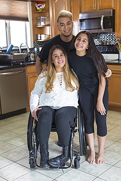 Woman who has Spinal Cord Injury standing with her friends in the kitchen