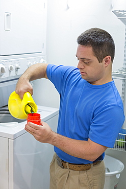 Man with Down Syndrome pouring laundry detergent