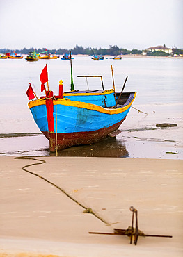 Colourful fishing boat tied to the beach, Ke Ga Cape; Ke Ga, Vietnam