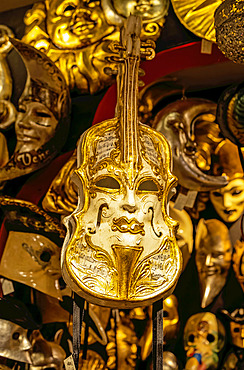 Gold violin on display with Venetian masks; Venice, Italy