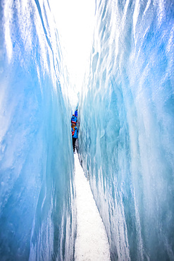 A tight squeeze for travelers exploring New Zealand's famous Franz Josef Glacier, iwth its blue Ice, deep crevasses, caves and tunnels that mark the ever changing ice formations; West Coast, New Zealand