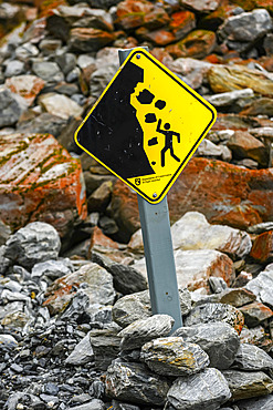 Cautionary sign placed on rocky trail to beware of falling rocks along the Franz Josef Glacier Walk in Westland Tai Poutini National Park; Whataroa, West Coast Region, South Island, New Zealand