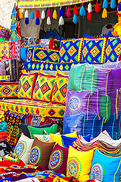 Colorful market stall selling pillows and cushions in traditional patterned fabrics at the Souq Waqif market place in Doha, Doha, Qatar