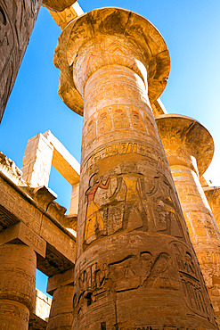 Close-up view of the hieroglyphics on the columns of the Great Hypostyle Hall, reaching up towards the blue sky in the Karnak Temple Complex near Luxor, Precinct of Amun-Re, Luxor, Egypt