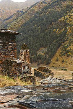 Historic stone house and tower with autumn coloured trees on the mountainside in the village of Dartlo in Tusheti National Park, Dartlo, Kakheti, Georgia