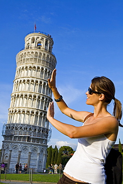 Young woman posing for photo with the Leaning Tower of Pisa, Pisa, UNESCO World Heritage Site, Tuscany, Italy, Europe