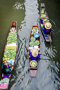 Vendors paddle their boats, Damnoen Saduak Floating Market, Thailand.