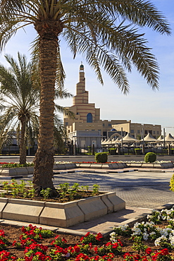 Palm trees and flower beds along Al-Corniche, waterfront promenade, with Qatar Islamic Cultural Centre, Doha, Qatar, Middle East