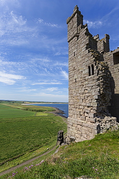 Ruins of Dunstanburgh Castle, overlooking fields and Embleton Bay, Northumberland, England, United Kingdom, Europe