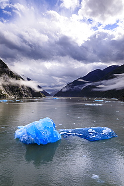 Spectacular Tracy Arm Fjord, brilliant blue icebergs and backlit clearing mist, mountains and South Sawyer Glacier, Alaska, United States of America, North America