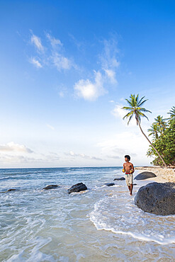 A local man walking along North Beach, Little Corn Island, Islas del Maiz (Corn Islands), Nicaragua, Central America