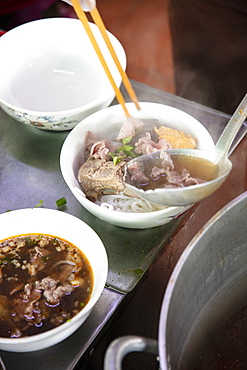 A steaming dish of Bun Bo Hue, the spicy local beef broth or hotpot, in a local restaurant, Hue, Vietnam, Indochina, Southeast Asia, Asia