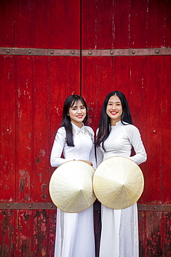 Two young women in traditional dress standing at the Western gateway to the Purple Forbidden City, Hue, Vietnam, Indochina, Southeast Asia, Asia