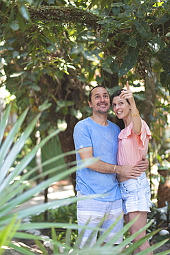 Tropical forest or hotel garden setting and middle-aged couple holding each other and happy together, Bahia, Brazil, South America