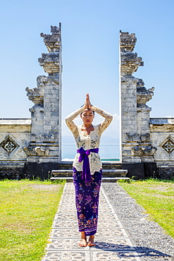 A young Balinese woman in traditional temple at the shoreside Pura Candidasa Hindu temple, Bali, Indonesia, Southeast Asia, Asia