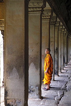 Buddhist monk in a colonnaded corridor in a temple in Angkor Wat, UNESCO World Heritage Site, Siem Reap, Cambodia, Indochina, Southeast Asia, Asia