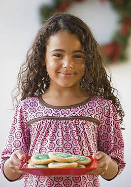 African girl holding plate of cookies