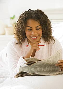 African woman reading newspaper