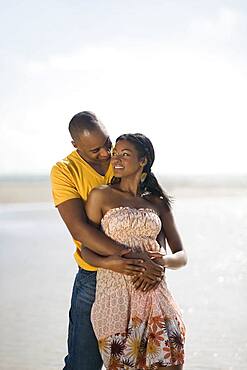 Multi-ethnic couple hugging at beach