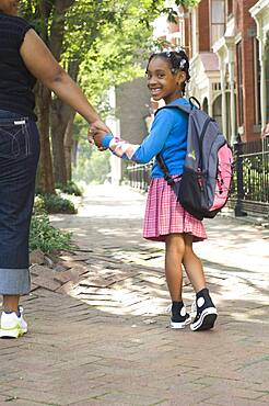 African mother and daughter holding hands