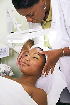 African woman receiving spa facial treatment