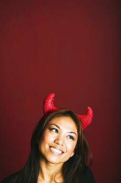 Asian woman wearing devil's horns