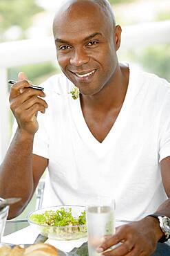 African American man eating salad